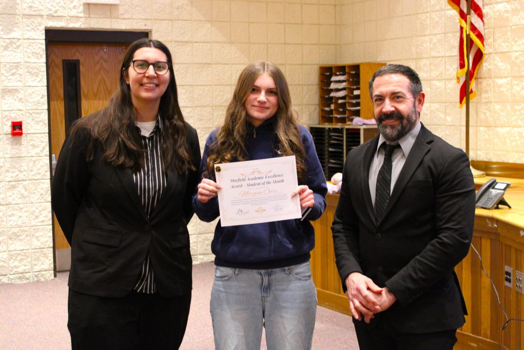 Students holding a certificate stands between principals