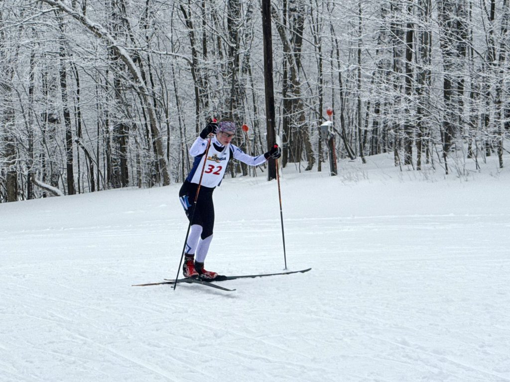 student in snowy woods on cross country skis
