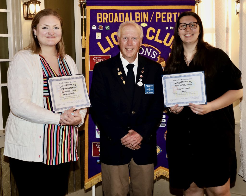 Three people stand together holding a certificate