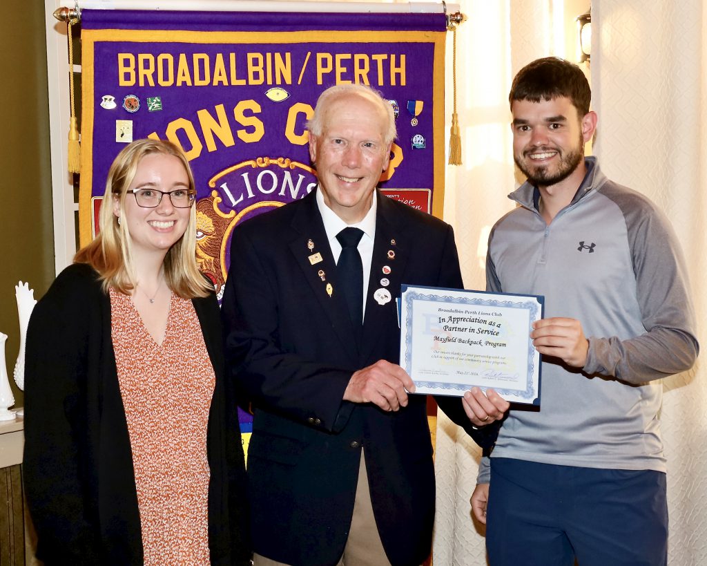 Three people stand together holding a certificate