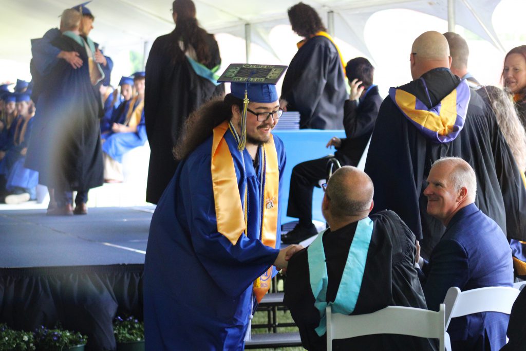 Graduate shaking hands with teacher