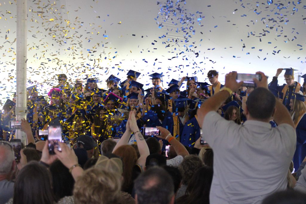 Graduates throw confetti in the air