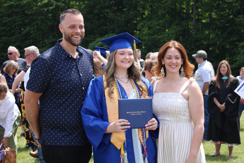 graduates poses with family