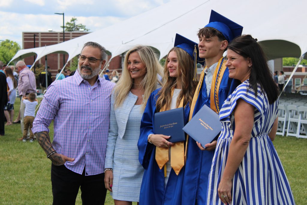 Family and two graduates pose for photo