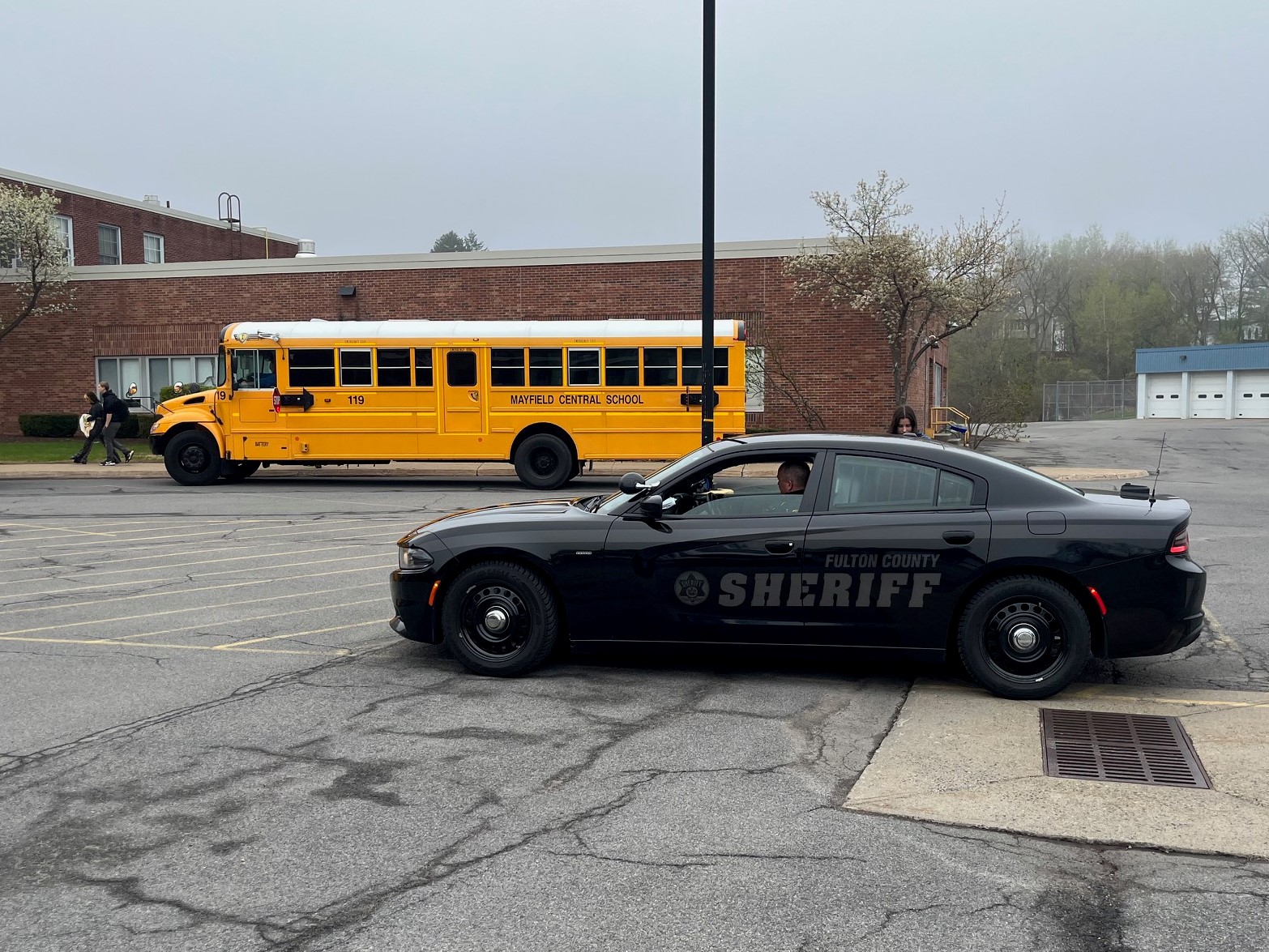 Sheriff patrol car in parking lot with school bus