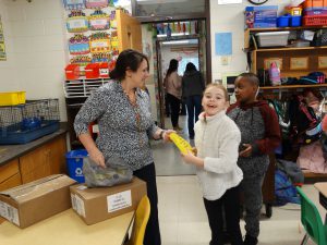 Teacher hands dictionary to student