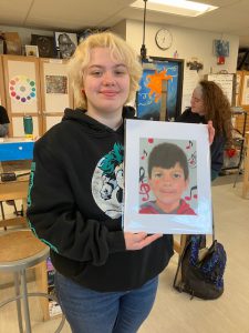 Student holds portrait.