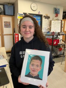 Student holds portrait.