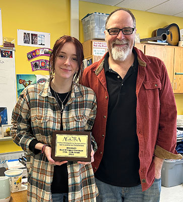 Bri holding award standing next to art teacher