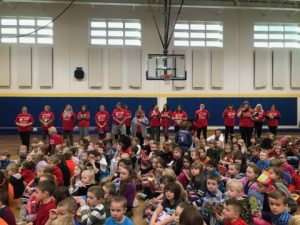 Staff dresses in red shirts line the gym