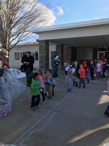 Students line up to drop off their toys