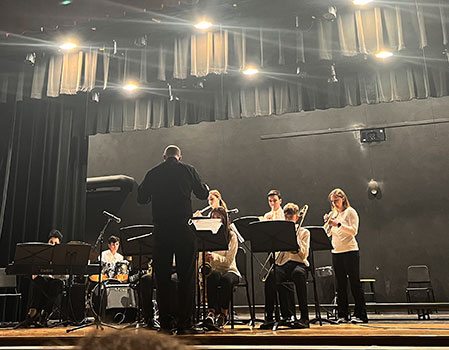 students on a stage playing instruments 