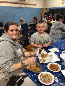 Mom and son work on a gingerbread house