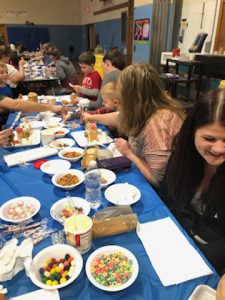 Students and parent make Gingerbread houses