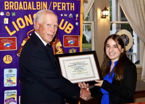 two people shake hands as an award is given