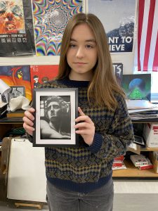 student holding up her artwork