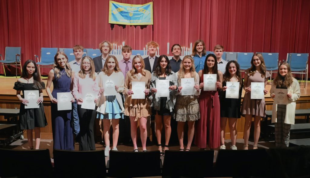 Newly inducted NHS members posing together on the stage