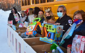 Transportation staff lined up with toys in front of a Mayfield bus