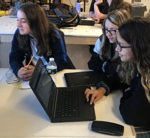 Three students do computer work