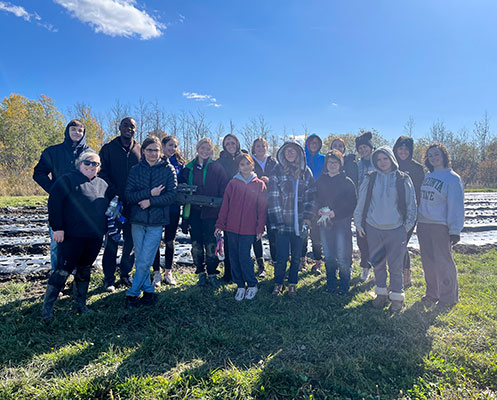 students and staff standing in a group outside