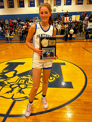 Cloey Dopp in gym holding plaque