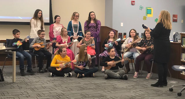 Students playing ukuleles at the Board of Education meeting