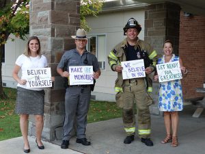 Adults holding signs to greet students