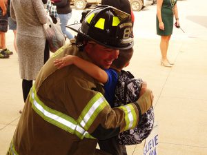 Student hugging a firefighter