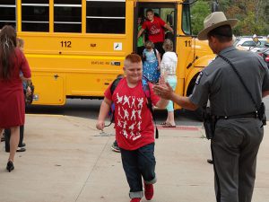 Student high fiving a police officer