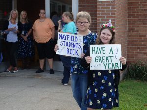 Students holding signs to greet students