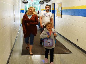 Family walking into the side door of the school