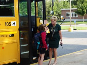 Principal Hitrick greets a student on the bus