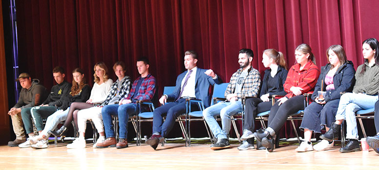 group of alumni sitting on stage