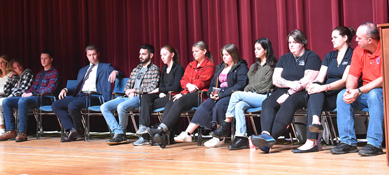 group of alumni sitting on stage