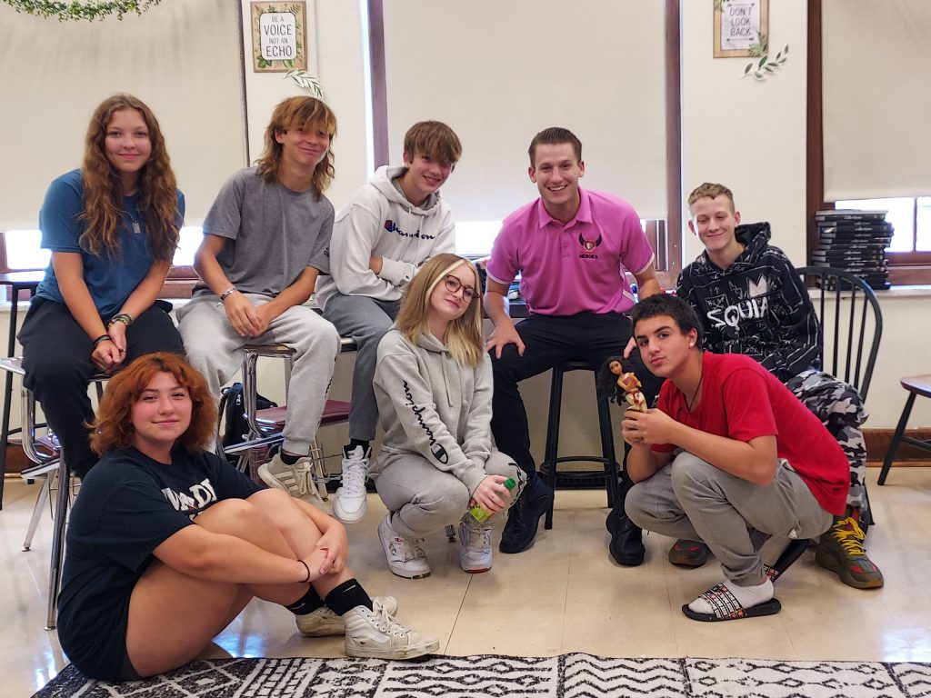 group of students sitting with Pat Fish in a classroom