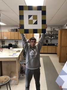 Student holding up project