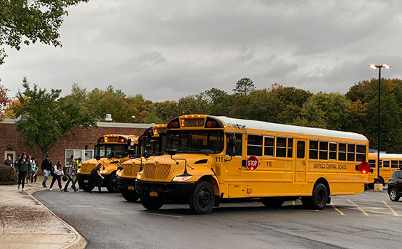 students walking to school buses outside high school